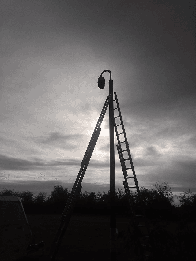 A tall, mobile CCTV tower standing in a field, monitoring a remote infrastructure project.